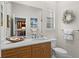 A stylish bathroom with a large mirror, wood vanity, and beach-themed decorations at 11447 Savannah Lakes Dr, Parrish, FL 34219