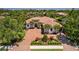 Beautiful Mediterranean-style home boasts lush landscaping, a paver driveway, and a grand double-door entrance at 11447 Savannah Lakes Dr, Parrish, FL 34219