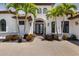 Elegant Mediterranean-style home boasting a tile roof, arched entry, and manicured landscaping along the paver driveway at 11447 Savannah Lakes Dr, Parrish, FL 34219
