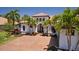 Charming Mediterranean home featuring meticulously manicured landscaping, a tile roof, and a welcoming double door entry at 11447 Savannah Lakes Dr, Parrish, FL 34219