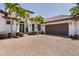 Attractive Mediterranean-style home featuring a tile roof, arched entry, and a well-manicured brick paver driveway at 11447 Savannah Lakes Dr, Parrish, FL 34219