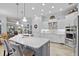 Modern kitchen with stainless appliances, center island, white cabinetry, and tile floors at 11447 Savannah Lakes Dr, Parrish, FL 34219