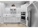 Bright white kitchen featuring marble backsplash, stainless steel appliances and ample cabinets at 11447 Savannah Lakes Dr, Parrish, FL 34219