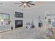 Bright living room with tile floor, ceiling fan, fireplace, and view of the kitchen at 11447 Savannah Lakes Dr, Parrish, FL 34219