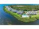 An aerial view shows multiple waterfront homes, luscious landscaping, and a beautiful pool at 12 Tidy Island Blvd, Bradenton, FL 34210