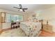 Cozy bedroom featuring a floral comforter, ceiling fan, and a charming window desk setup at 12 Tidy Island Blvd, Bradenton, FL 34210