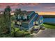 Stunning waterfront home featuring a blue exterior, a new roof, a paver driveway, and lush landscaping at 12 Tidy Island Blvd, Bradenton, FL 34210