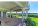 Spacious covered patio with brick pavers, lush landscaping, and spiral staircase to the above living space at 12 Tidy Island Blvd, Bradenton, FL 34210