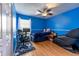 Blue bedroom with a ceiling fan, a desk, and a comfortable massage chair at 12026 Warwick Cir, Parrish, FL 34219