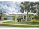 Beautiful home with lush green lawn and mature palm trees enhancing its appeal at 12026 Warwick Cir, Parrish, FL 34219