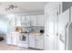 Modern kitchen with white cabinets, updated appliances, and marble countertops complemented by tile flooring at 12026 Warwick Cir, Parrish, FL 34219