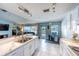 Open concept kitchen with white cabinets, marble countertops, stainless steel appliances, and a view of the pool area at 12026 Warwick Cir, Parrish, FL 34219