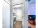 Hallway view into laundry room, with modern washer and dryer, plus storage at 12026 Warwick Cir, Parrish, FL 34219