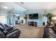Open-plan living room with leather sofas and a TV on the wall, with seamless access to the dining area at 12026 Warwick Cir, Parrish, FL 34219