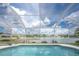 Enclosed pool and lanai with putting green offer a tranquil outdoor space overlooking scenic lake views at 12026 Warwick Cir, Parrish, FL 34219