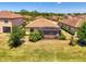 An appealing rear exterior view featuring a screened lanai, lush lawn, and well-maintained landscaping at 12315 Canavese Ln, Venice, FL 34293