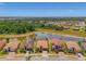 Panoramic aerial view of the property with a serene pond and lush green spaces and a nearby street at 12315 Canavese Ln, Venice, FL 34293