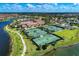 Aerial view of community tennis courts near community clubhouse and lake at 12315 Canavese Ln, Venice, FL 34293