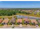 Neighborhood aerial view showcasing the landscape, the pond, nearby homes and streets at 12315 Canavese Ln, Venice, FL 34293
