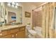 Well-lit bathroom with a granite vanity, tiled floors, and a shower-tub combination with a glass enclosure at 12315 Canavese Ln, Venice, FL 34293
