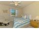 Cozy bedroom with blue and white striped bedding, a ceiling fan, and natural light at 12315 Canavese Ln, Venice, FL 34293