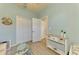 Bright bedroom with pale blue walls, a large closet, wood-look flooring and charming seaside accents at 12315 Canavese Ln, Venice, FL 34293