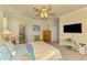 Serene bedroom with beachy décor, TV, and en-suite bath featuring a luxurious soaking tub at 12315 Canavese Ln, Venice, FL 34293