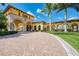 Front of the grand clubhouse entrance lined with a circular driveway and landscaping at 12315 Canavese Ln, Venice, FL 34293