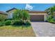 Charming single-Gathering home with a red-tiled roof, two-car garage, paver driveway, and tropical landscaping at 12315 Canavese Ln, Venice, FL 34293