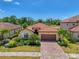 Beautiful single-Gathering home featuring a red-tiled roof, paver driveway, two-car garage, and lush tropical landscaping at 12315 Canavese Ln, Venice, FL 34293