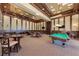 Elegant game room with a pool table, card tables, and comfortable seating, perfect for entertaining guests at 12315 Canavese Ln, Venice, FL 34293