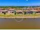 Aerial view of the home's backyard, featuring a screened lanai, lawn and a serene pond setting at 12315 Canavese Ln, Venice, FL 34293
