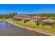 Aerial view of homes along a lake featuring a screened-in lanai, lush lawns and waterside tranquility at 12315 Canavese Ln, Venice, FL 34293