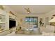 Bright living room features neutral colors, ceiling fan, media center, and glass doors to the outdoors at 12315 Canavese Ln, Venice, FL 34293