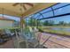 Relaxing screened patio with elegant dining set, overlooking a serene pond and lush landscaping at 12315 Canavese Ln, Venice, FL 34293
