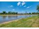 Scenic view of the pond, with the house in the background, under a clear blue sky with light clouds at 12315 Canavese Ln, Venice, FL 34293