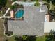 Birds-eye view featuring an outdoor pool and patio nestled between lush landscaping and the home's unique roof at 127 Mill E Run, Bradenton, FL 34212