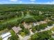 Aerial view of a lush property with pool, surrounded by mature trees and a serene pond at 127 Mill E Run, Bradenton, FL 34212