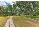 Spacious backyard featuring mature trees, pond view, and walking path at 127 Mill E Run, Bradenton, FL 34212