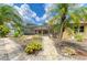 Beautiful backyard showcasing a screened pool, patio area, tropical foliage, and a clear blue sky at 127 Mill E Run, Bradenton, FL 34212