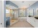 Bathroom features a walk-in shower, soaking tub, double vanities, and decorative chandelier at 127 Mill E Run, Bradenton, FL 34212