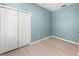 An empty bedroom featuring a light blue wall paint, light hardwood flooring, and a built-in closet at 127 Mill E Run, Bradenton, FL 34212