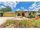 Charming yellow home featuring a red front door, well-manicured lawn, and a two-car garage at 127 Mill E Run, Bradenton, FL 34212