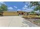 Lovely yellow home featuring a red front door, landscaped yard, long driveway, and a two-car garage at 127 Mill E Run, Bradenton, FL 34212