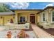 Inviting front porch with seating, decorative plants, and a red door offering a warm welcome at 127 Mill E Run, Bradenton, FL 34212