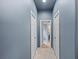 Hallway with doors leading to other rooms, neutral tile floors, and light blue walls at 127 Mill E Run, Bradenton, FL 34212