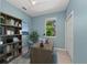 Comfortable home office with a wooden desk, bookshelf, blue chair and a window with natural light at 127 Mill E Run, Bradenton, FL 34212