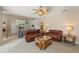 Bright living room featuring tile floors, ceiling fan, and leather sofas open to the kitchen at 127 Mill E Run, Bradenton, FL 34212