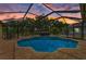 Screened in pool area featuring a spa and a brick patio, sunset sky at 127 Mill E Run, Bradenton, FL 34212