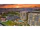 Stunning sunset view of luxury high-rise condos with a pool, lush landscaping, and ample parking near the bay and city at 130 Riviera Dunes Way # 502, Palmetto, FL 34221